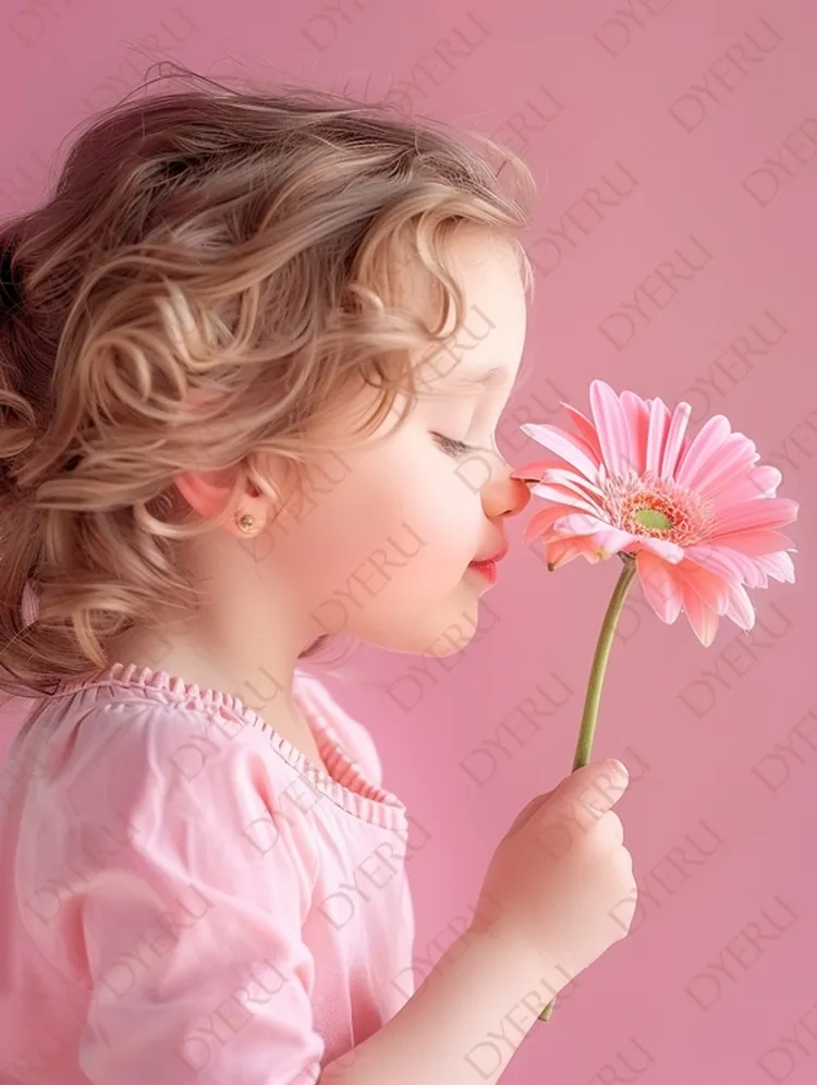 Urocza dziewczynka w różowej bluzce wącha różowego gerbera na tle różowej ściany